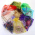 An arrangement of colorful organza gift bags containing assorted treasures like roses, jewelry, and dried flowers, each bag adorned with a WISE OWL 2-Tones Gold Filled Charm Bracelet for Women Fashion Jewelry Chain Gold and Silver on a pristine white background.